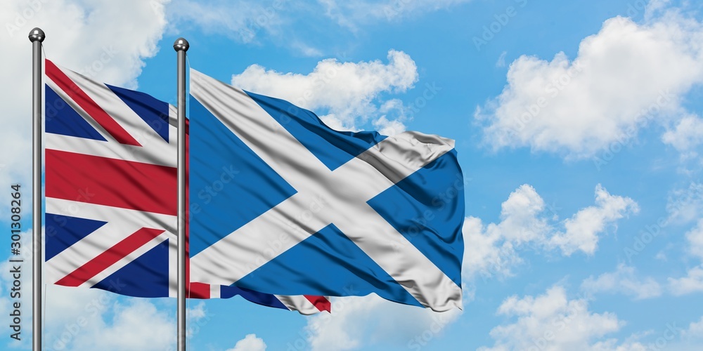United Kingdom and Scotland flag waving in the wind against white cloudy blue sky together. Diplomacy concept, international relations.
