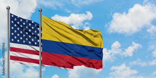 United States and Colombia flag waving in the wind against white cloudy blue sky together. Diplomacy concept, international relations.