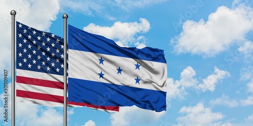 Foto United States and Honduras flag waving in the wind against white cloudy blue sky together