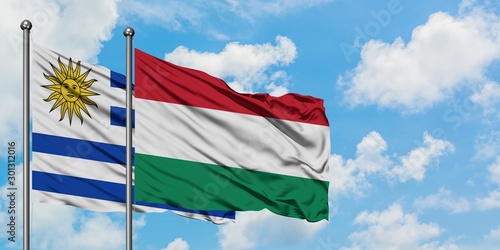 Uruguay and Hungary flag waving in the wind against white cloudy blue sky together. Diplomacy concept  international relations.