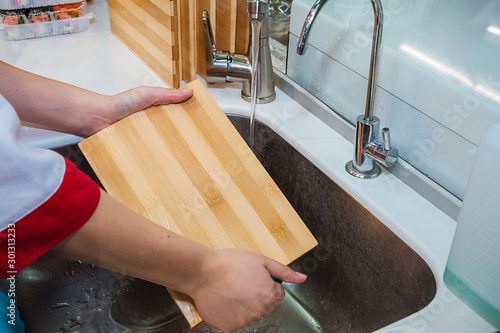 Bild auf Leinwand Washes a board under the tap