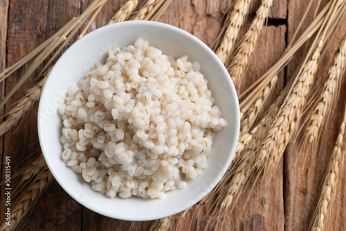 Canvas-taulu Cooked peeled barley grains in white bowl