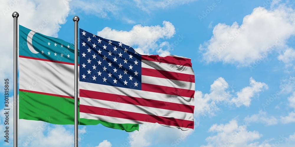 Uzbekistan and United States flag waving in the wind against white cloudy blue sky together. Diplomacy concept, international relations.