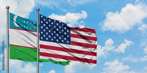 Uzbekistan and United States flag waving in the wind against white cloudy blue sky together. Diplomacy concept  international relations.