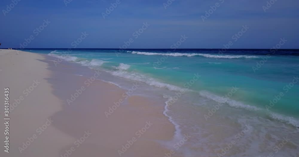 Waves of Shallow Green Ocean Moving Towards the Clean White Sand During Summer in Indonesia - Wide Shot Waves of Shallow Green Ocean Moving Towards the Clean White Sand During Summer in Indonesia - Wide Shot