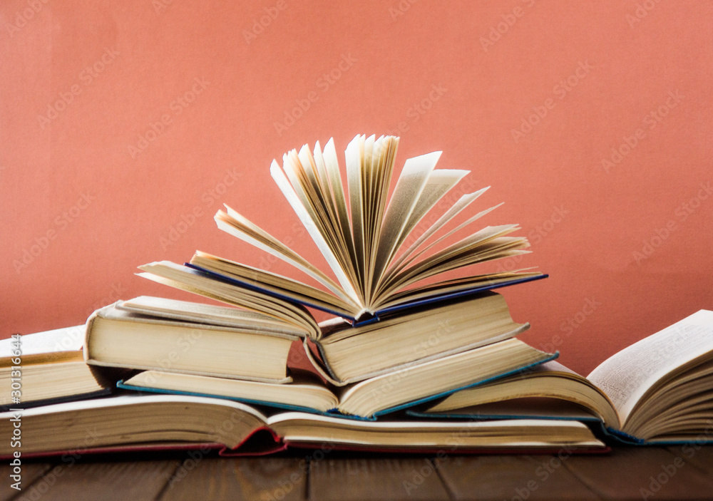 Fototapeta premium Stack of colorful books. Education background. Back to school. Book, hardback colorful books on wooden table. Education business concept. Copy space for text