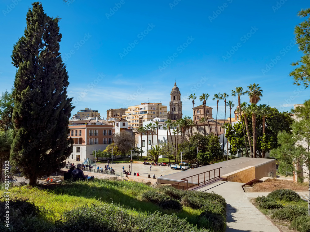 Fototapeta premium View of the roman theatre of Malaga, Spain on a sunny day. The Cathedral and Picasso Museum in the background.