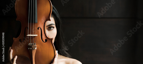 Close up portrait of young asian woman playing violin vintage style with copy space. Musician orchestra performer artist lifestyle concept panoramic banner