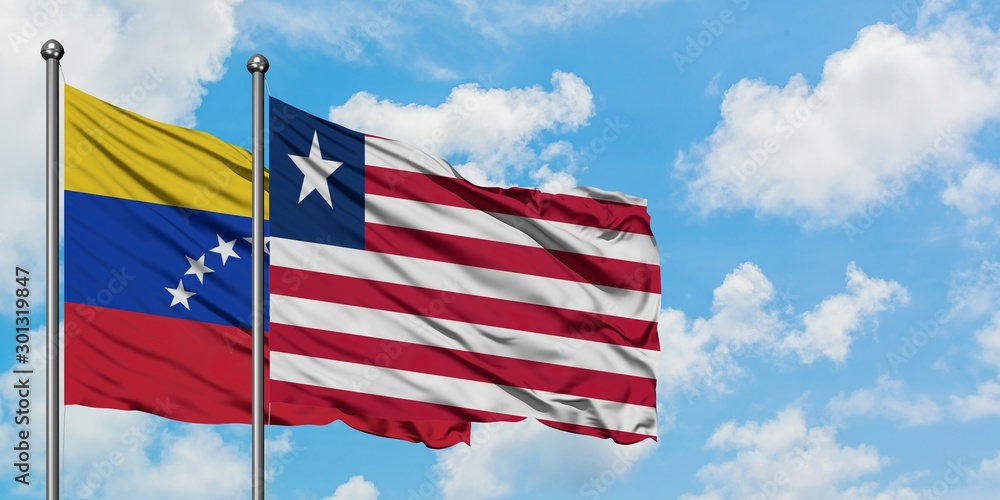 Venezuela and Liberia flag waving in the wind against white cloudy blue sky together. Diplomacy concept, international relations.