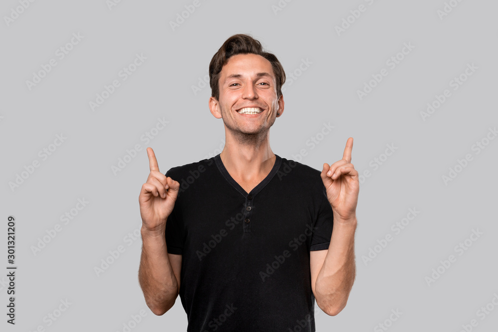 Smiling man in a black tee shirt pointing with finger up. Smiling man in a black tee shirt pointing with finger up.