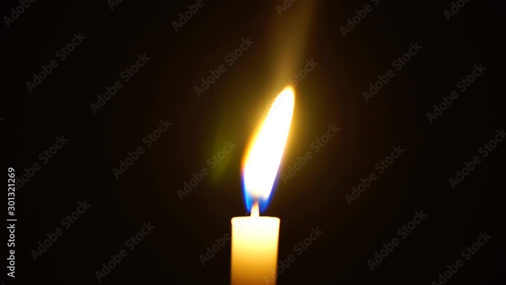 One candle light illuminated in a black background. One candle light illuminated in a black background.