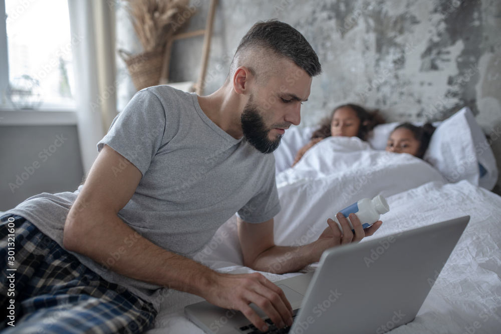 Bearded father reading information about vitamins for immunity Bearded father reading information about vitamins for immunity