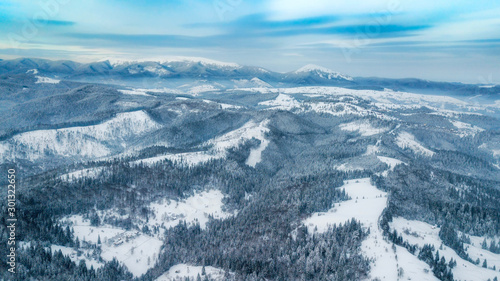 Fototapeta Naklejka Na Ścianę i Meble -  amazing winter landscape. mountains covered with snow and blue cloudy sky. drone shot,  bird's eye