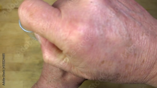 Slow motion close POV overhead shot of a man’s hands removing the cork of an unopened bottle of sparkling wine in an insulated cooling jacket, releasing the inert gas.