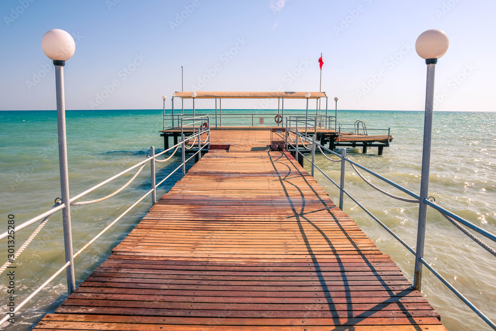 Wooden pier, weak water waves in the Mediterranean Sea, holiday scenes with a sense of calm.
