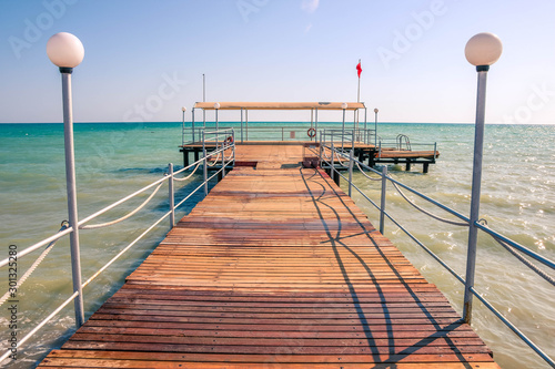 Fototapeta Naklejka Na Ścianę i Meble -  Wooden pier, weak water waves in the Mediterranean Sea, holiday scenes with a sense of calm.