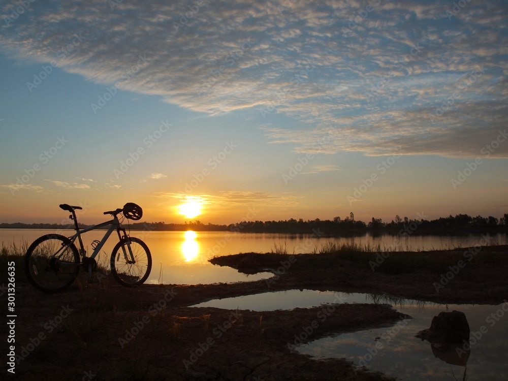 Fototapeta premium Mountain bike parked beside the reservoir in the morning