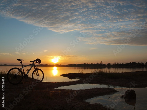 Mountain bike parked beside the reservoir in the morning