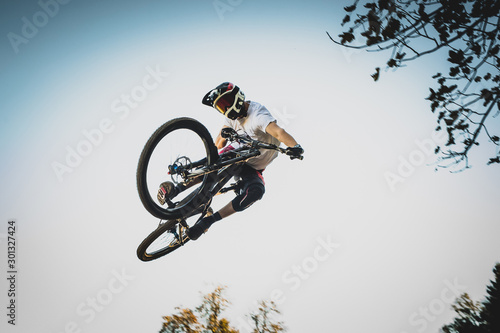 Mountain biker jumping over a dirt jump.