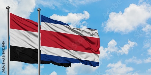 Yemen and Costa Rica flag waving in the wind against white cloudy blue sky together. Diplomacy concept, international relations.