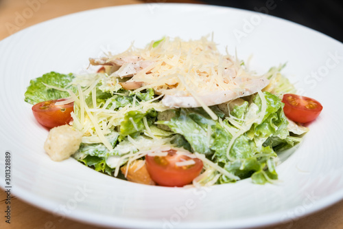 Plate with chicken salad on table. Healthy Grilled Chicken Caesar Salad with Cheese and Croutons.