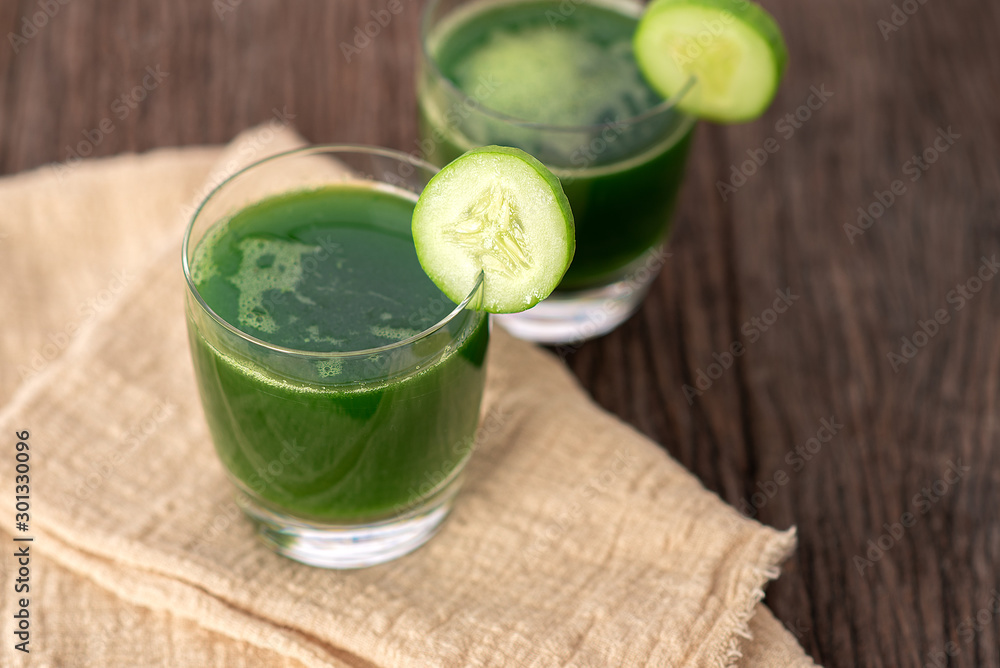Cold cucumber soup with avocado and mint,Glass of cucumber juice on grey wooden background Cold cucumber soup with avocado and mint,Glass of cucumber juice on grey wooden background