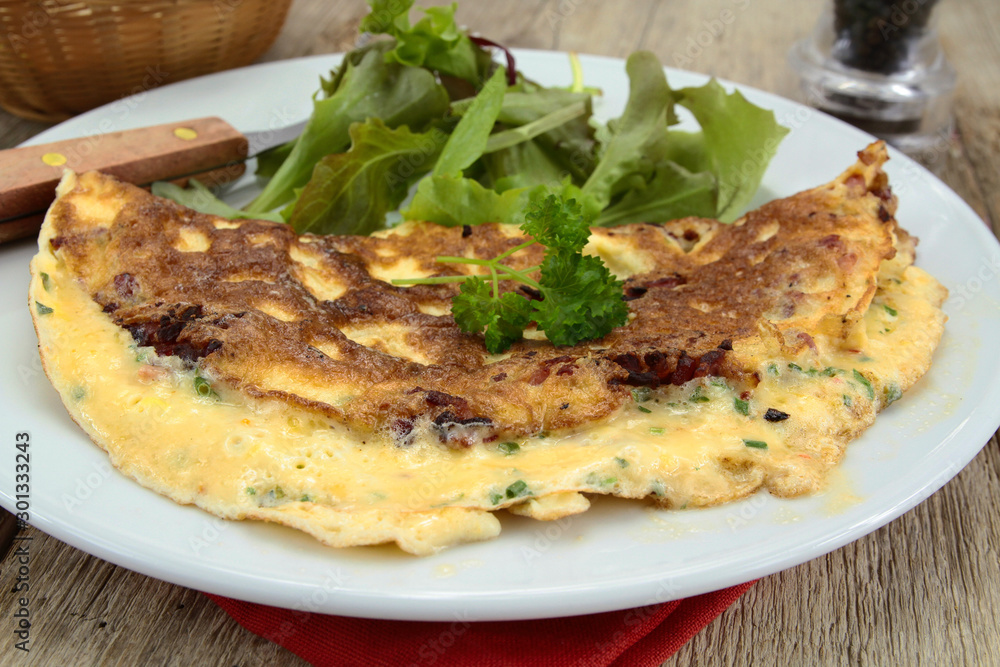 herbed omelette and bacon on a plate herbed omelette and bacon on a plate