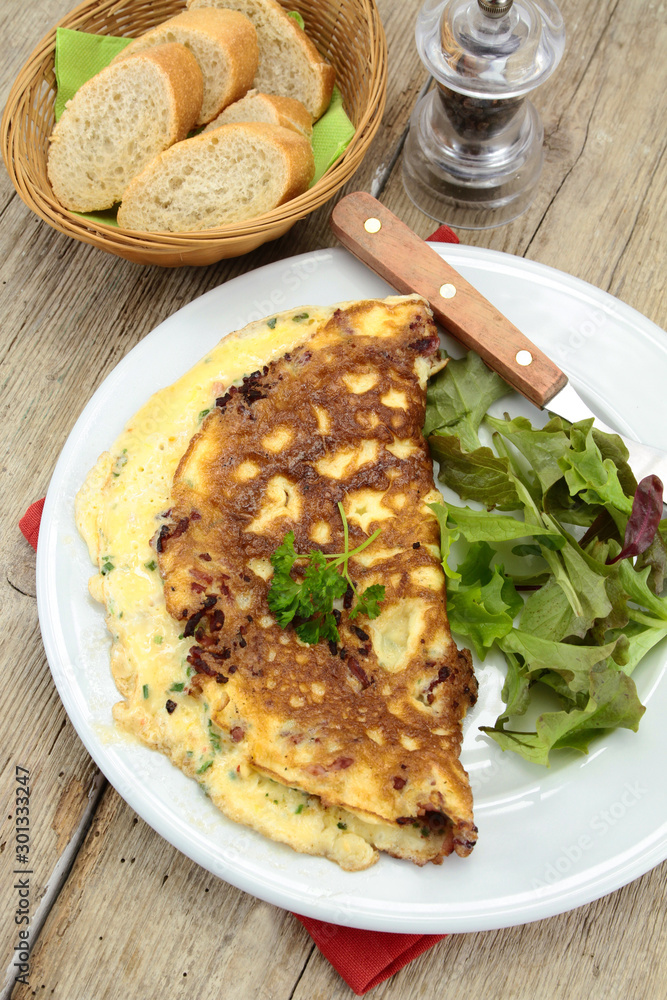 herbed omelette and bacon on a plate herbed omelette and bacon on a plate