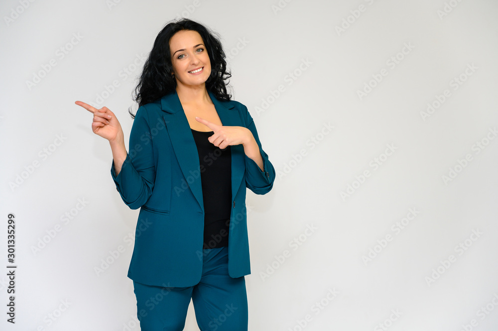 Portrait of a pretty brunette woman with long curly hair on a white background in a business suit. He stands in front of the camera, smiles, talks in various poses. Portrait of a pretty brunette woman with long curly hair on a white background in a business suit. He stands in front of the camera, smiles, talks in various poses.