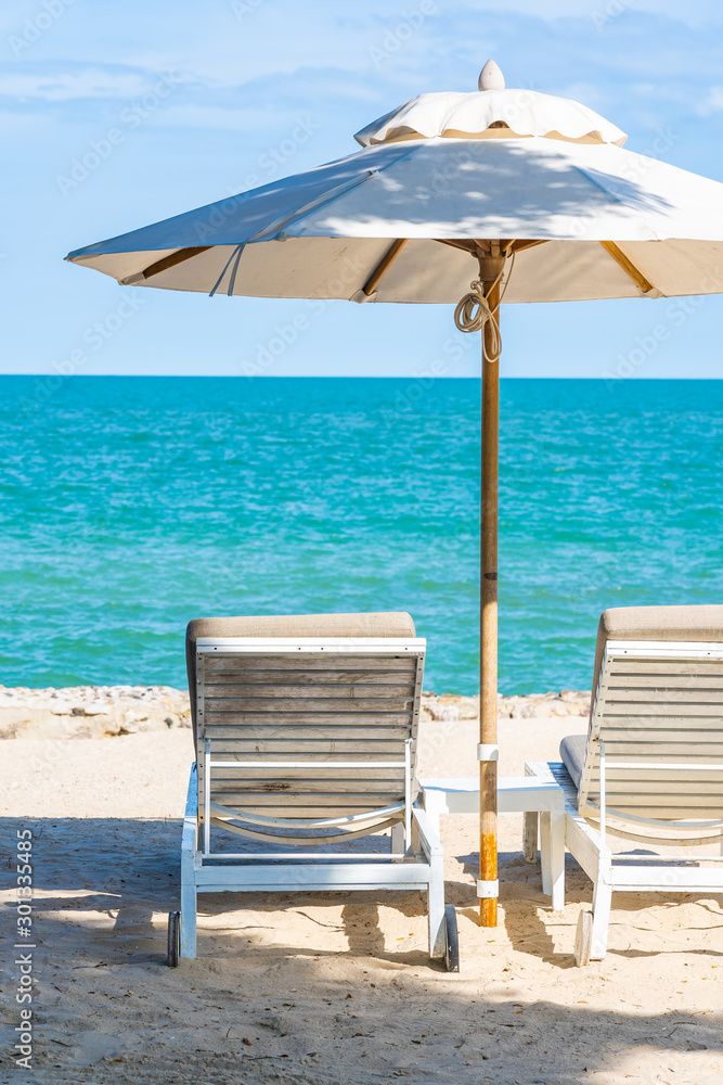 Beautiful umbrella and chair around beach sea ocean with blue sky for travel