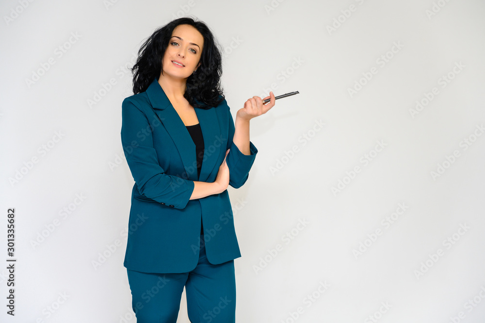 Portrait of a pretty brunette woman with long curly hair on a white background in a business suit. He stands in front of the camera, smiles, talks in various poses. Portrait of a pretty brunette woman with long curly hair on a white background in a business suit. He stands in front of the camera, smiles, talks in various poses.