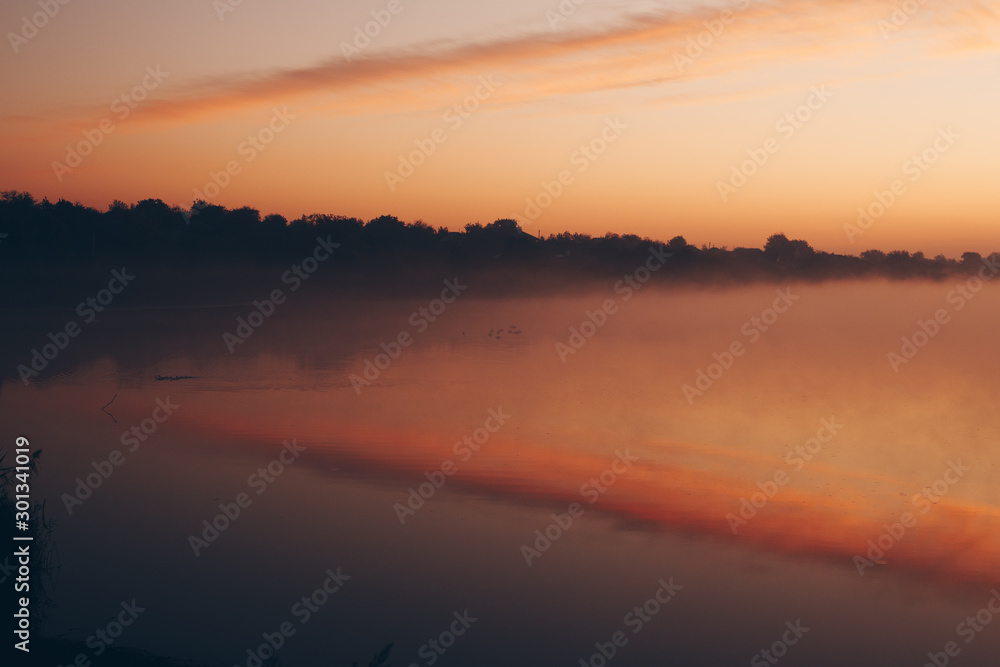 The lake at sunrise and above it is fog
