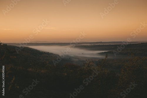 In the morning at sunrise and fog at the foot of the mountains