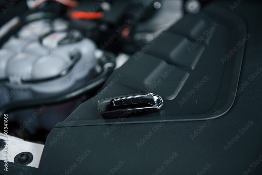 Repairing is done. Black keys leaning under the hood of automobile Repairing is done. Black keys leaning under the hood of automobile