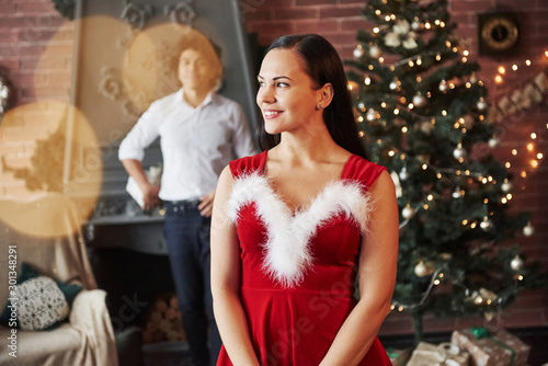Surprise time. Woman in red dress will now receive Christmas gift from boyfriend © standret