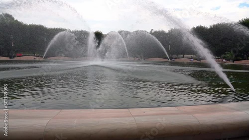 Slow motion of a large circular fountain with water jets all around it photo