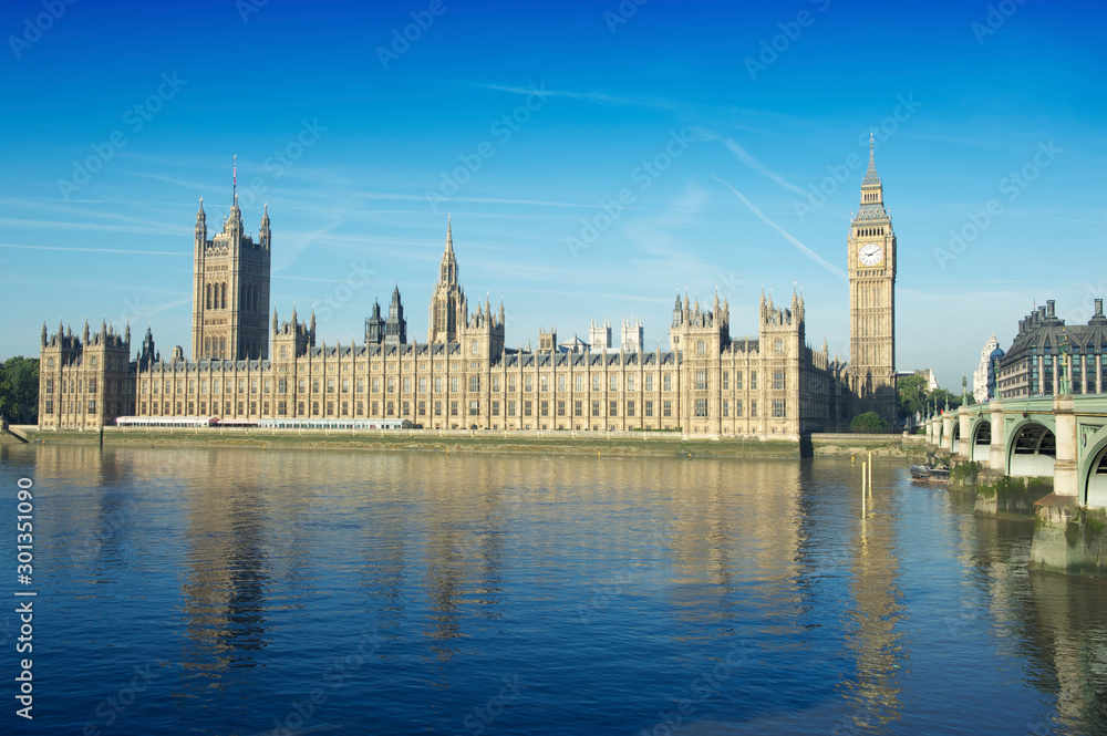 Scenic view of Big Ben and the Houses of Parliament at Westminster Palace with the arches of the nearby bridge over the River Thames in London, UK