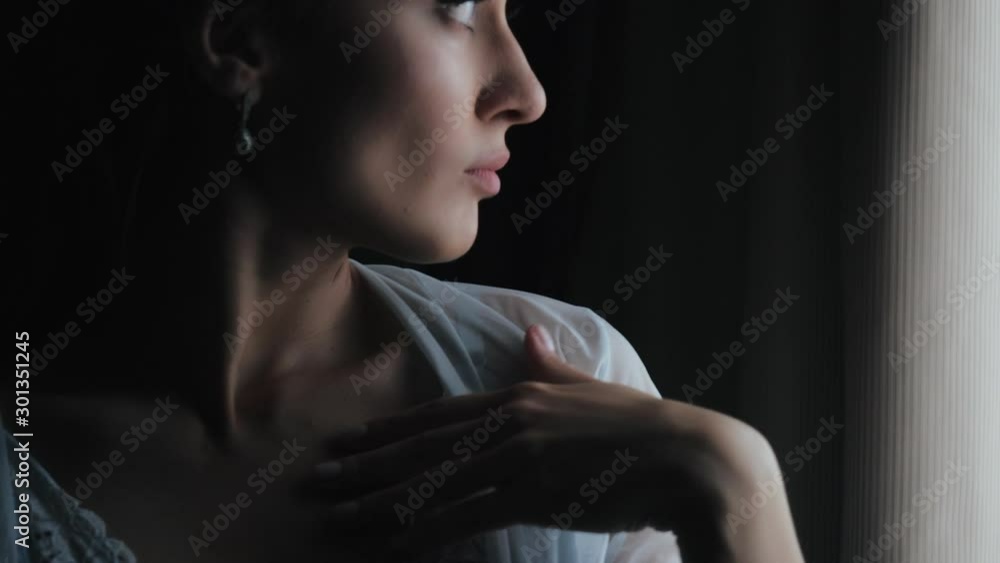 Beautiful sexy lady in elegant peignoir puts hands to her lips and shoulders, smiles, shyly turns away. Fashion model girl portrait with sexy mole looking at camera. Beautiful sexy lady in elegant peignoir puts hands to her lips and shoulders, smiles, shyly turns away. Fashion model girl portrait with sexy mole looking at camera.