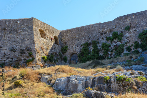 bottom view of the mountain with part of the stone wall with wooden doors of the fortress of Fortezza. Summer  Greece  Rethymno.