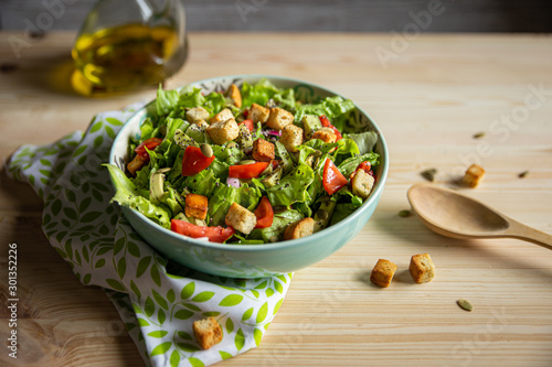 Φωτογραφία salad with tomatoes, avocados, croutons and wooden spoon