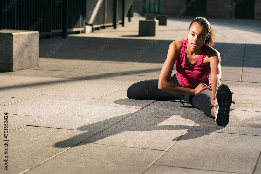 Fototapeta premium Athlete stretching muscles at the training stock photo