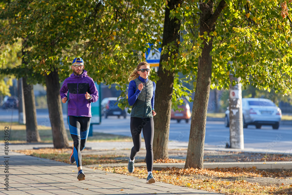 Obraz premium Young couple run on the street in the morning