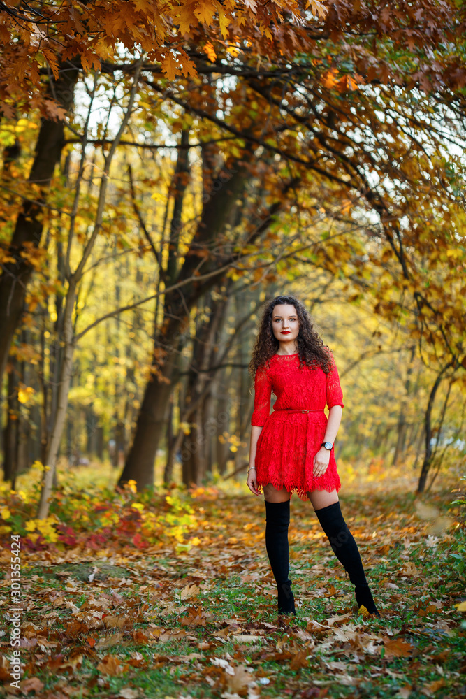 girl with curls in a red dress in the autumn forest girl with curls in a red dress in the autumn forest