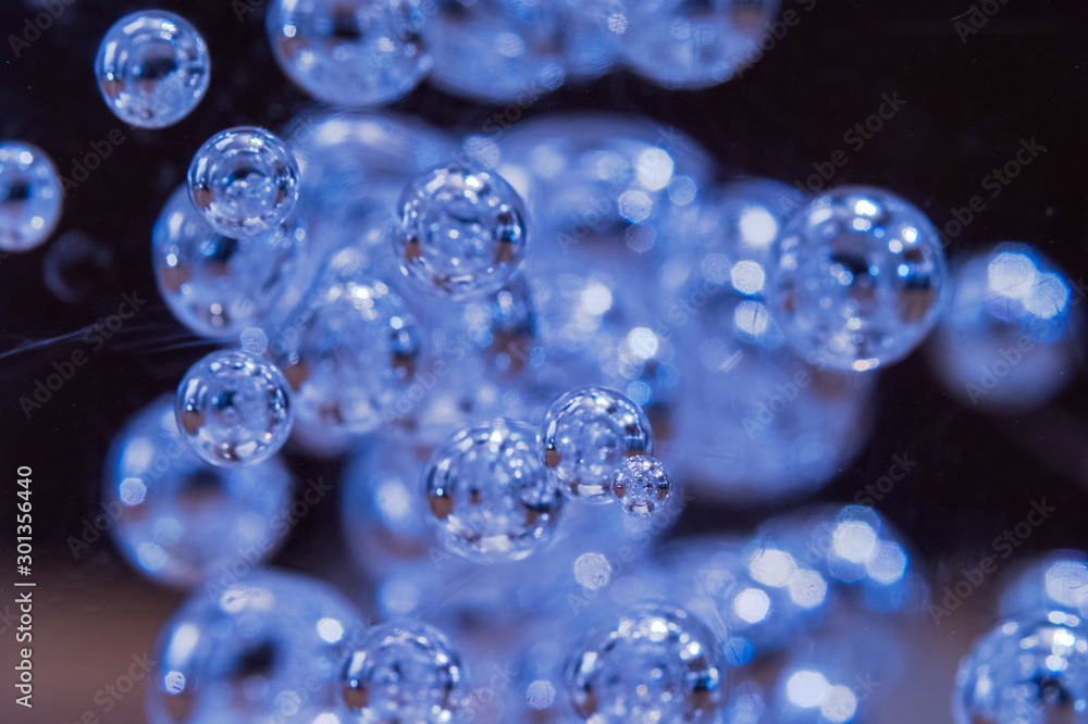 Illuminated Blue Bubbles Floating in Clear Liquid Seen Through ...