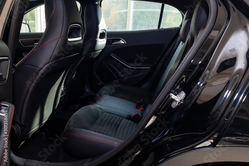 Clean after washing the rear passenger seats of matte black genuine leather inside the interior of an expensive suv, preparation before selling the car. Auto service industry. detailing cleaning. © Aleksandr Kondratov