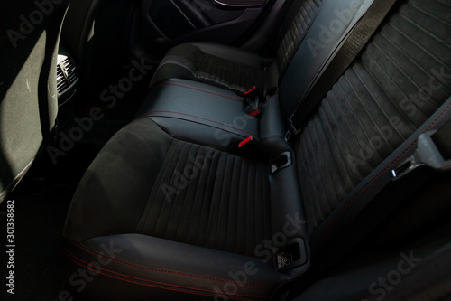 Clean after washing the rear passenger seats of matte black genuine leather inside the interior of an expensive suv, preparation before selling the car. Auto service industry. detailing cleaning.