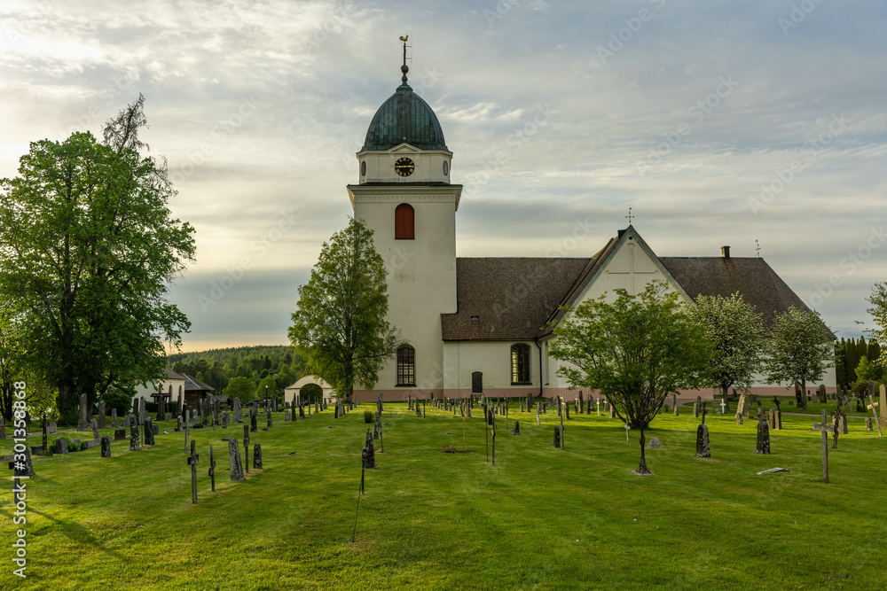 Old church with a green cemetery on the Swedish countryside