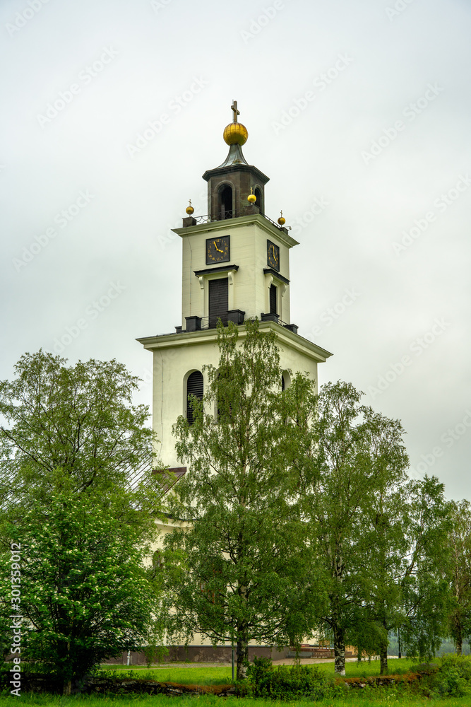 White church in northern Sweden surrounded by green trees