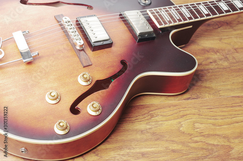 Hollow jazz guitar on wooden texture background