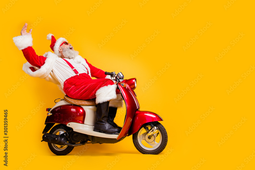 Full length profile side photo of crazy funky white bearded santa claus hipster ride fast his scooter hurry on christmas x-mas wear shirt suspenders isolated over yellow color background